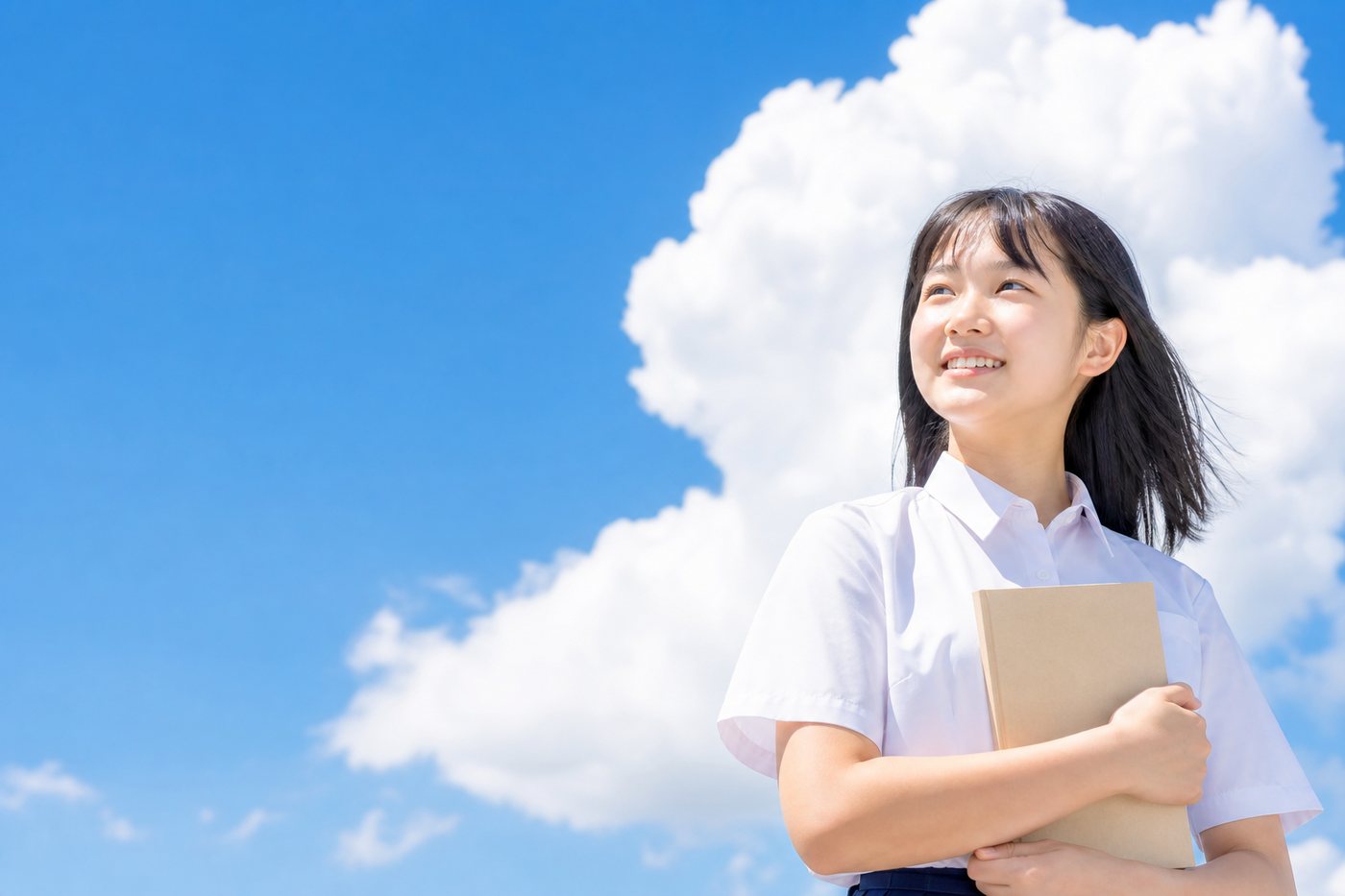 夏の青空を背にほほえむ女子生徒
